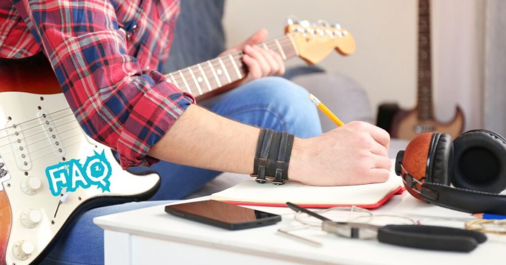 guitar composition FAQ - a person holding a pencil and writing on a notebook